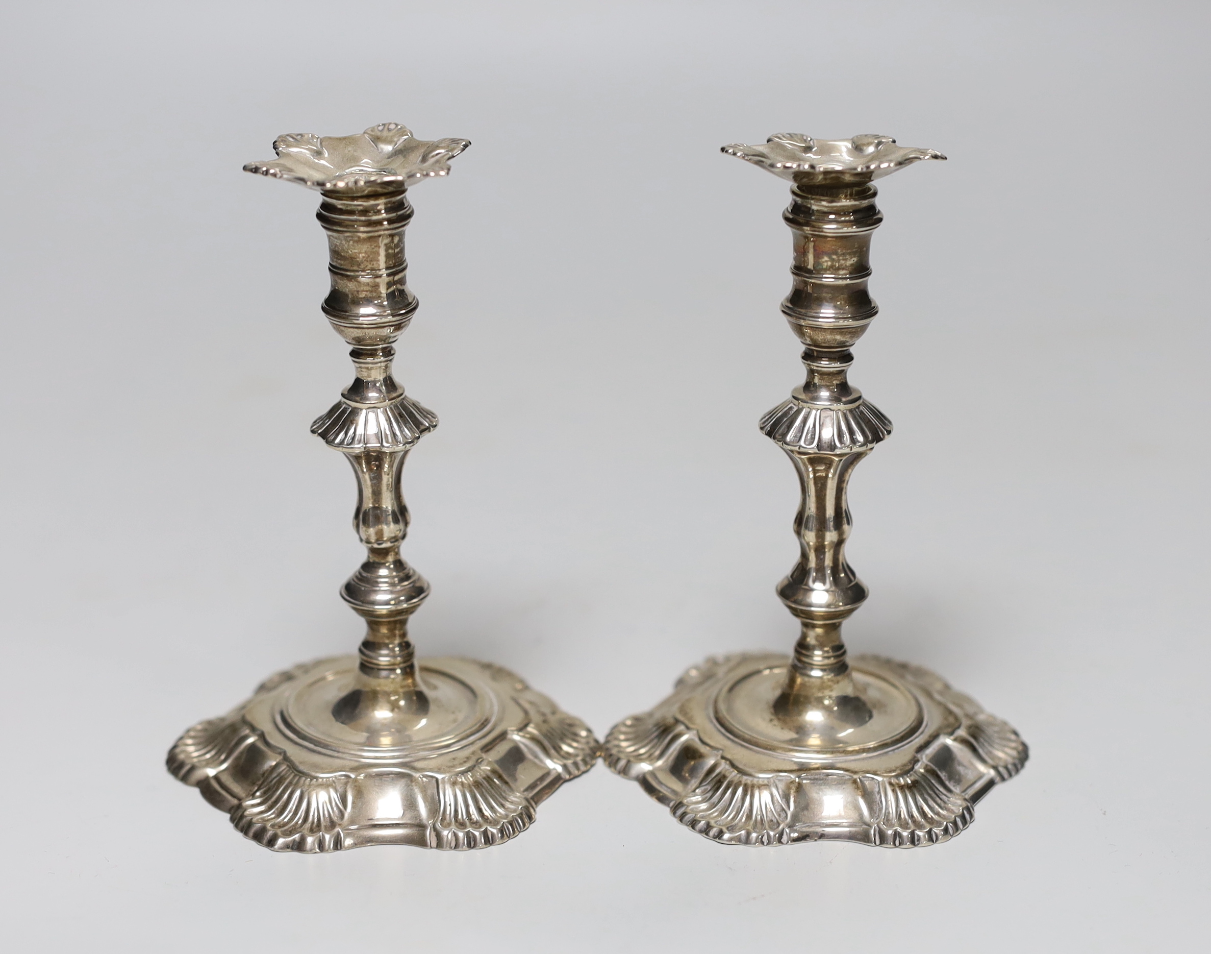 A pair of George II cast silver taper sticks, with unmarked nozzles, by John Cafe, London 1749/1750, 12.6cm, 11.7oz.